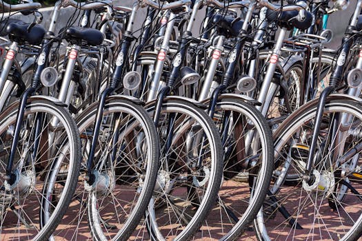 A detailed view of multiple bicycles parked in an outdoor urban area, showcasing wheels and handlebars.
