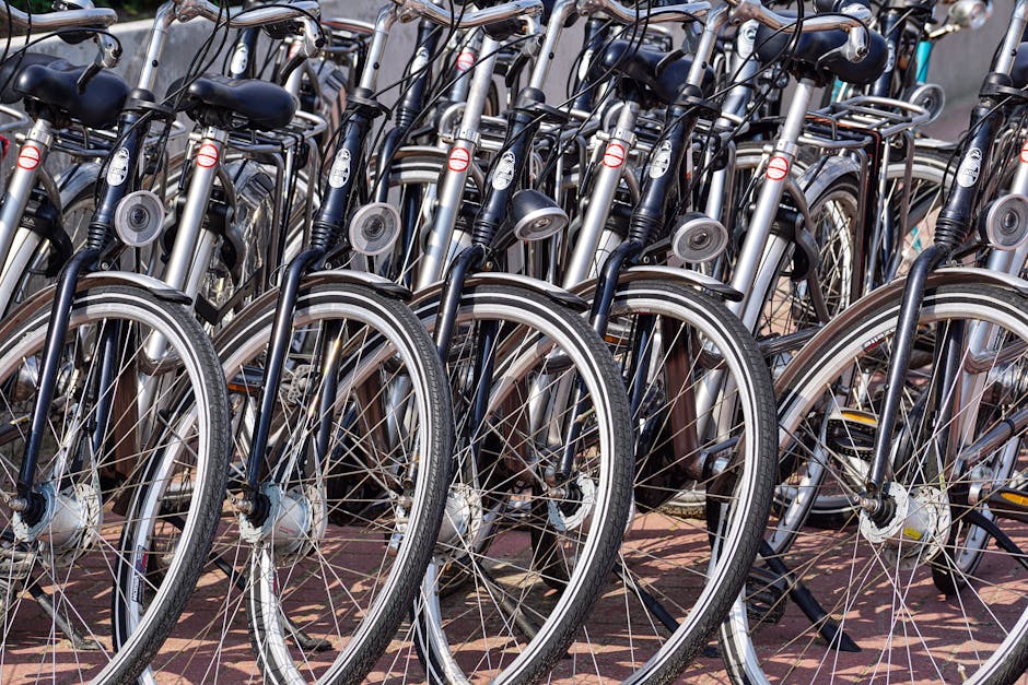 A detailed view of multiple bicycles parked in an outdoor urban area, showcasing wheels and handlebars.