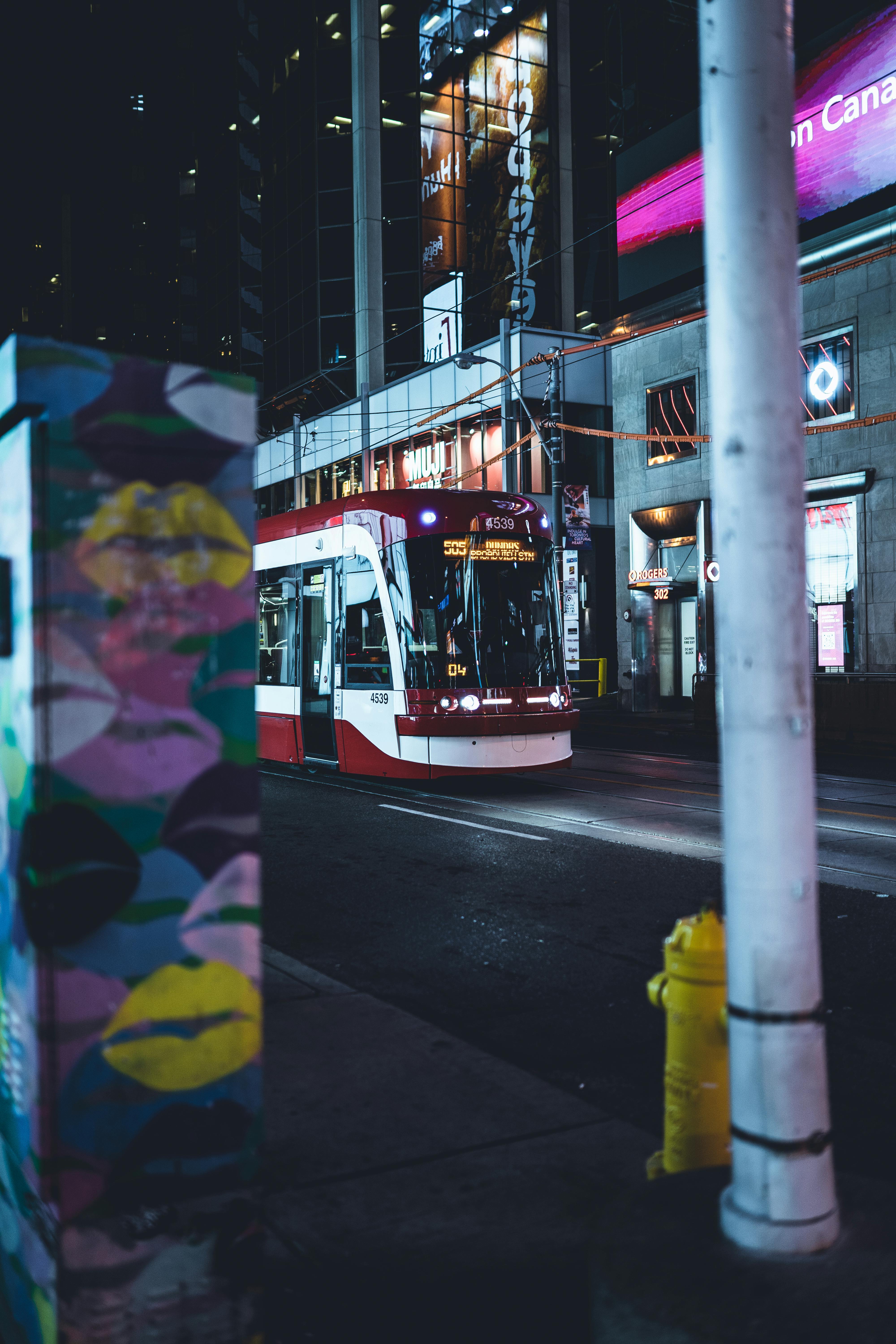 Free A vibrant streetcar navigates the lively streets of Toronto at night, capturing urban life. Stock Photo