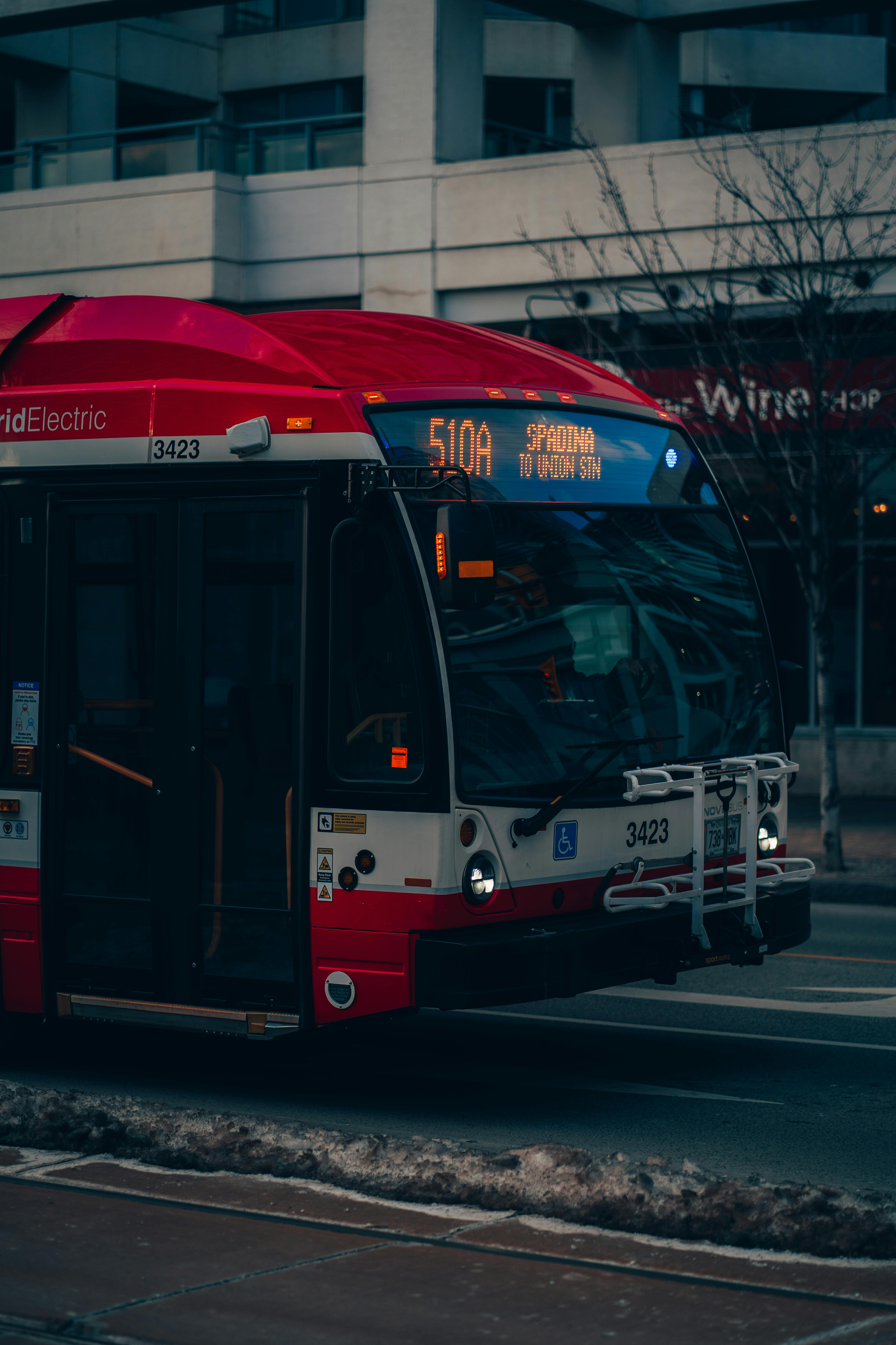Free A vibrant red streetcar captures the essence of public transportation in downtown Toronto. Stock Photo