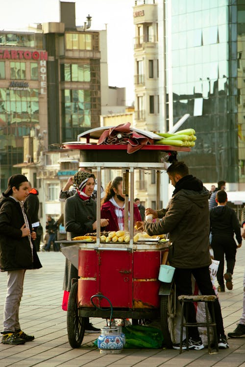 A Vendor Selling Corn with Street Cart 