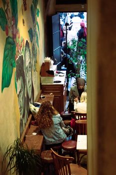 Intimate café in İstanbul featuring a colorful mural and lively atmosphere.