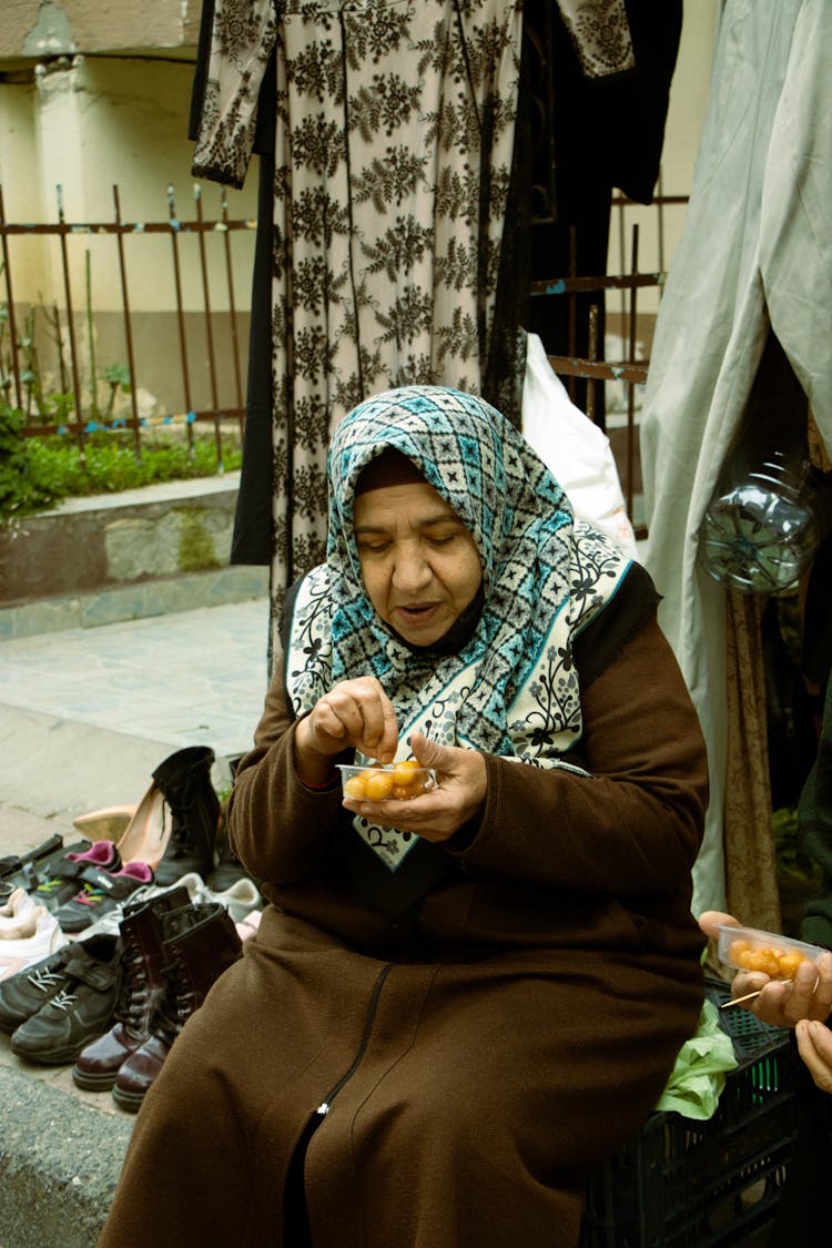 A Woman Eating On The Street