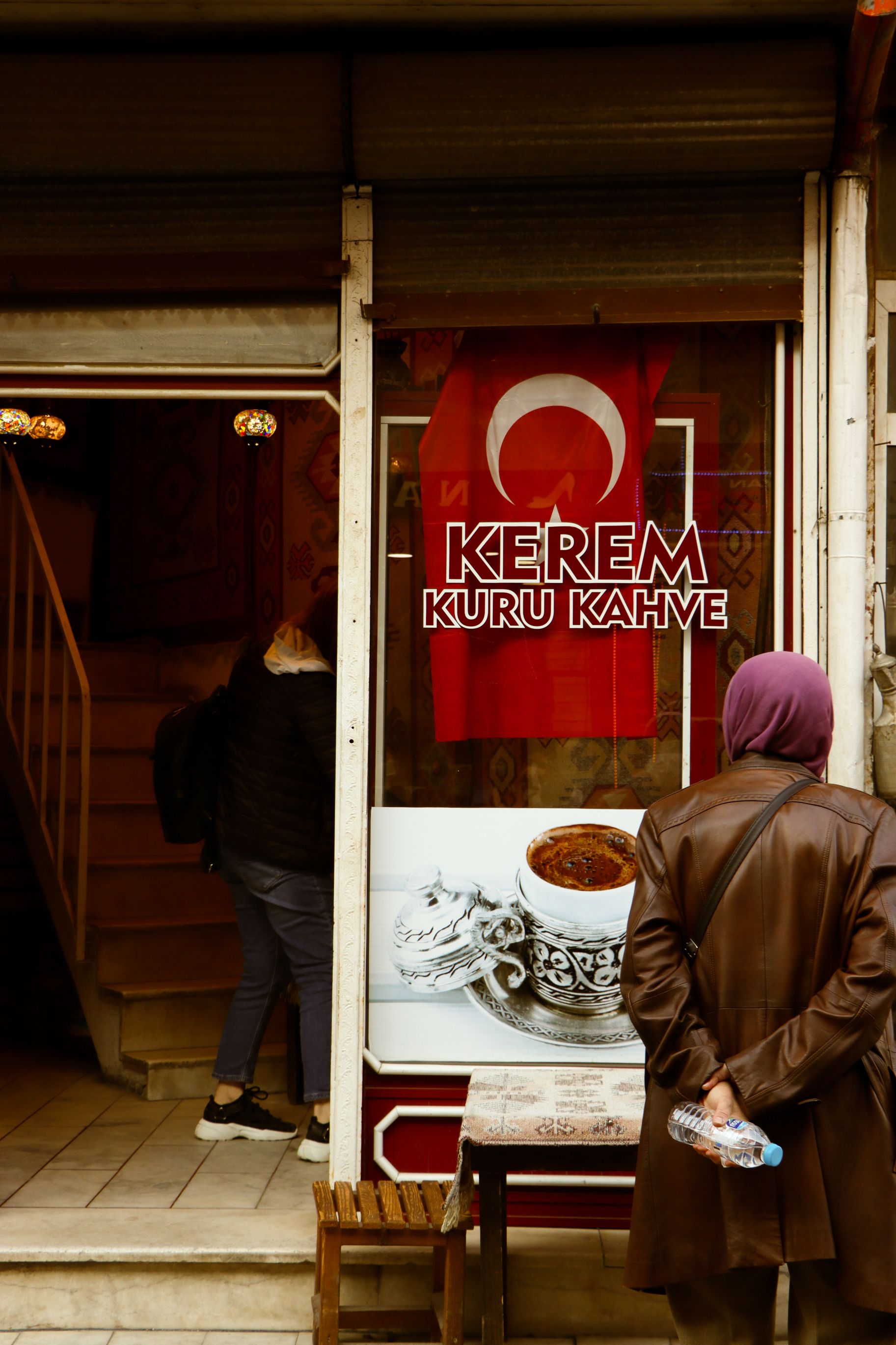 A street view of a Turkish coffee shop in Afyonkarahisar, featuring a woman outside and traditional decor.