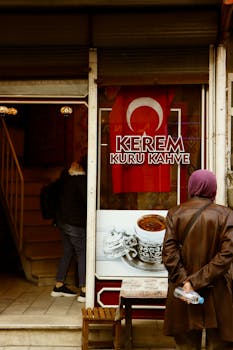 A street view of a Turkish coffee shop in Afyonkarahisar, featuring a woman outside and traditional decor.