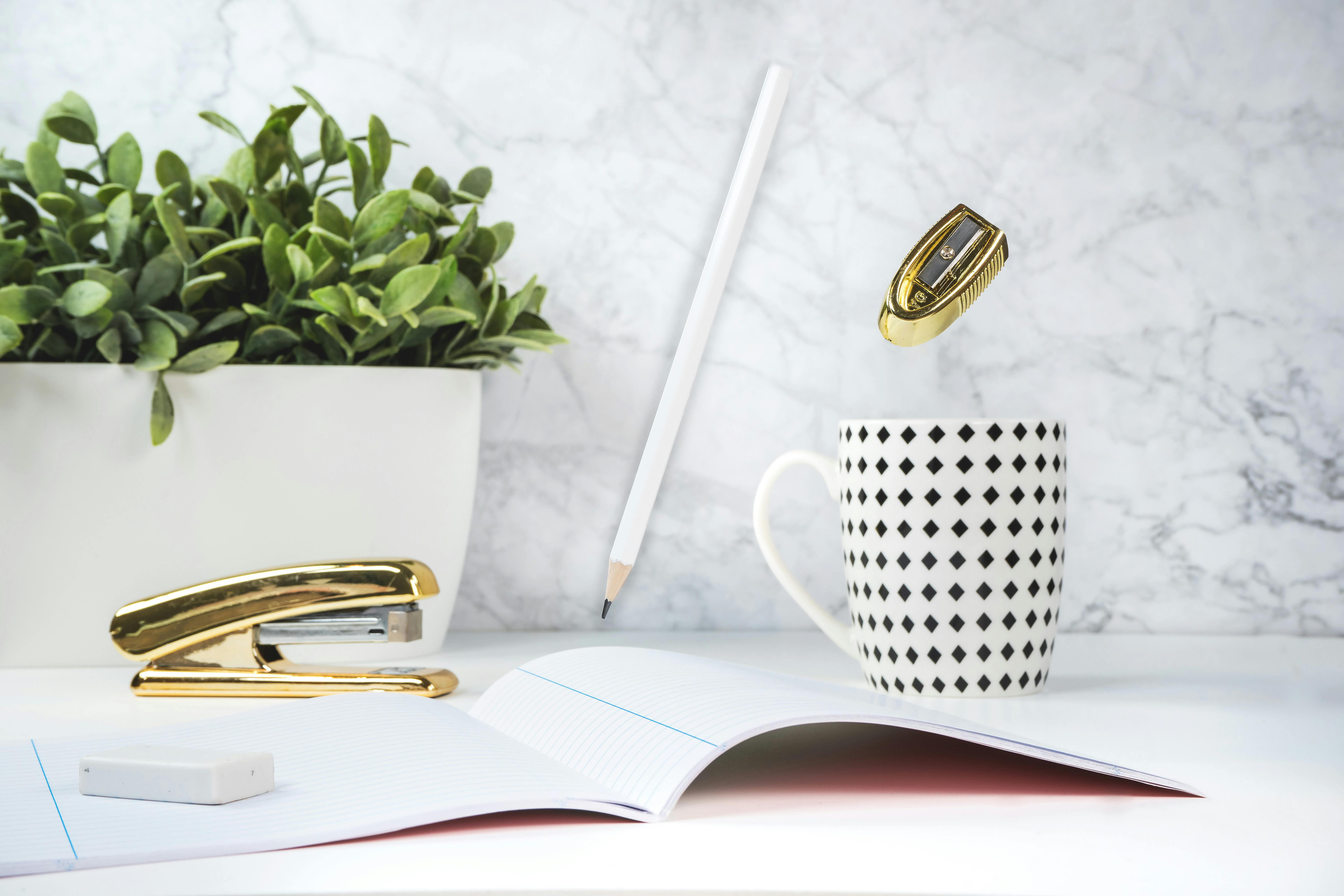 white and black ceramic mug on the table