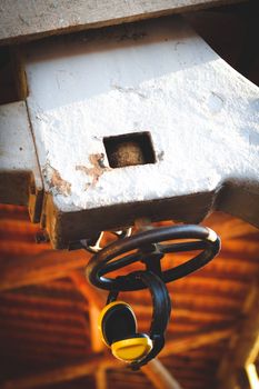 Close-up of industrial hanging earmuffs on machinery, showcasing details and textures.