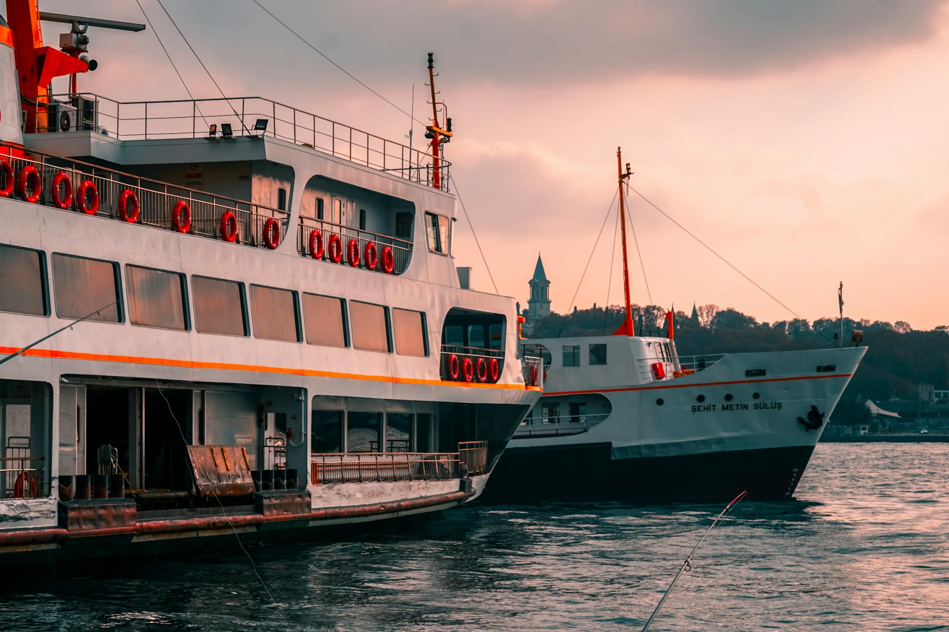 Ferry boats on the Bosphorus in Istanbul, Turkey captured during sunset, showcasing vibrant colors and iconic landmarks.