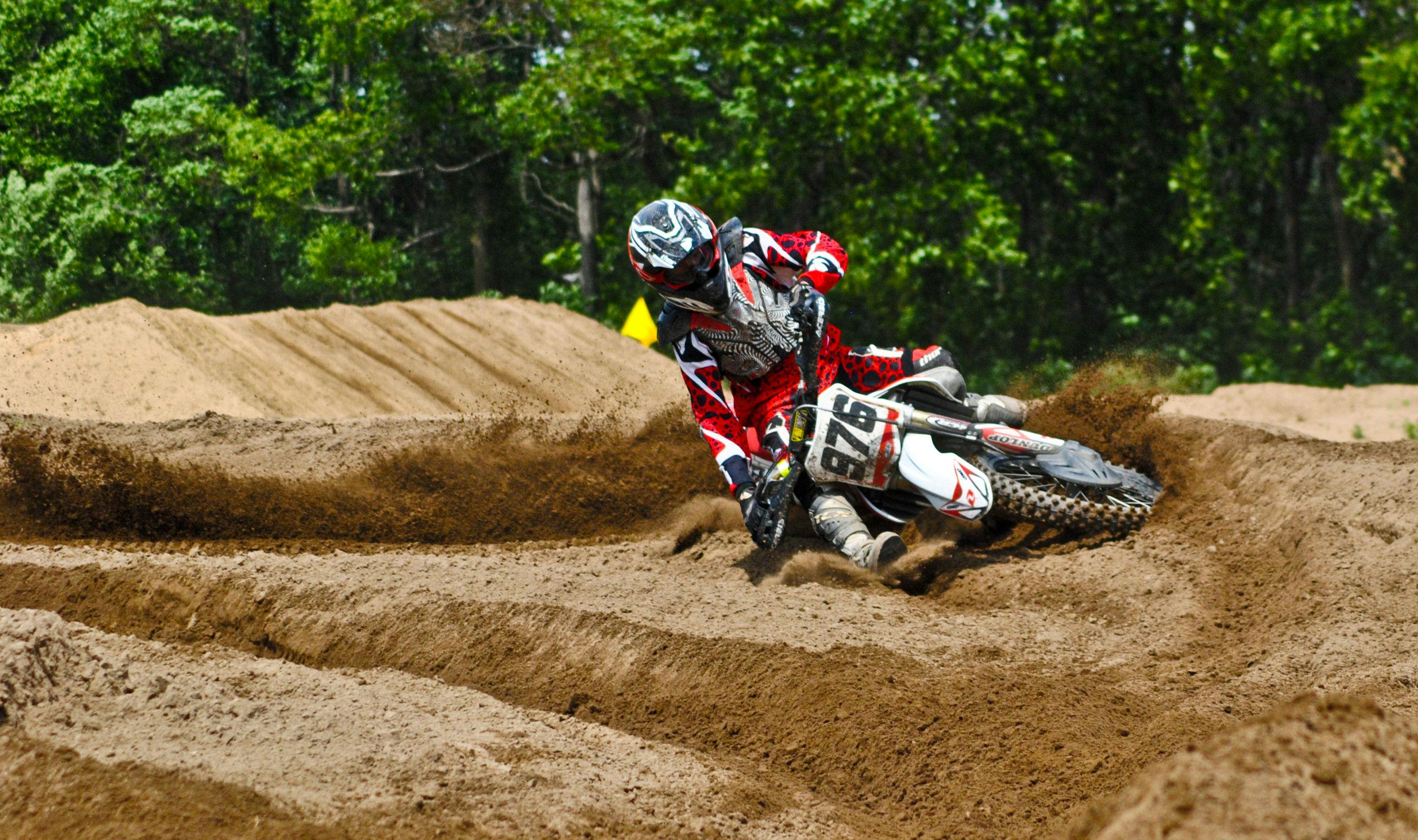 person driving dirt motorcycle on sandy stadium
