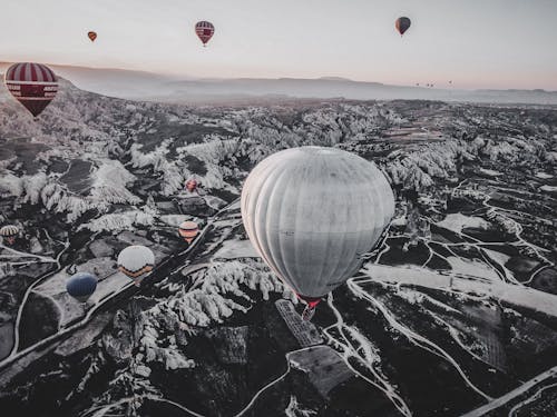Hot Air Balloons Floating over Snow Covered Mountains