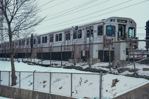 A winter scene featuring a train near Kipling Station in Toronto, Canada.