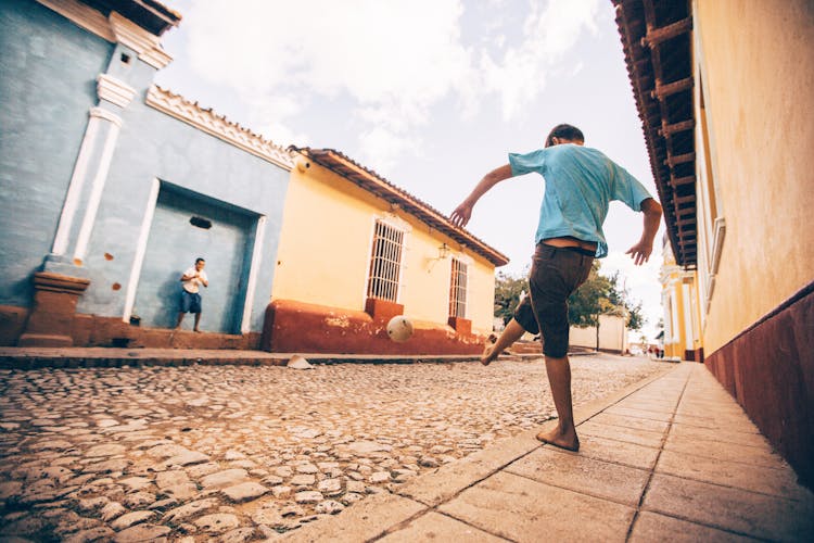 A Low Angle Shot Of A Man Kicking The Ball