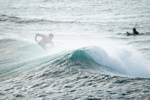 A Man Surfing on the Beach