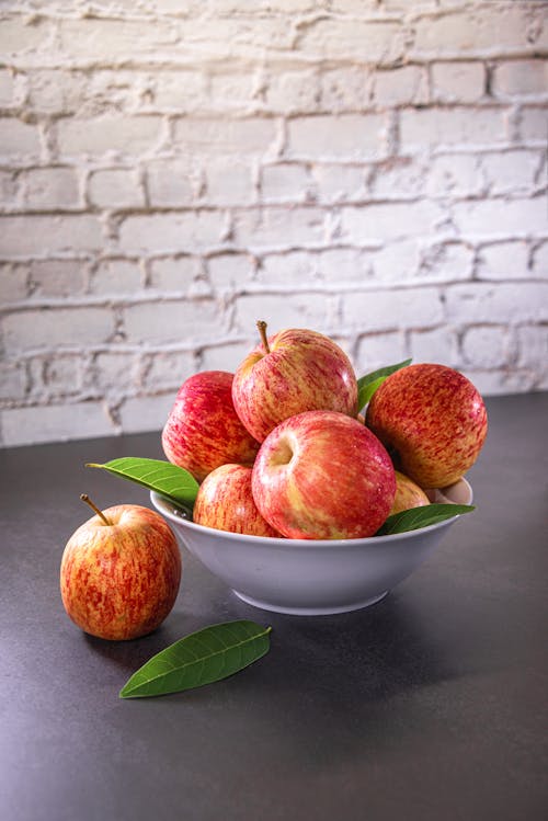 Rode Appels Met Groene Bladeren In De Kom Op De Zwarte Tafel En Witte Tegels Achtergrond