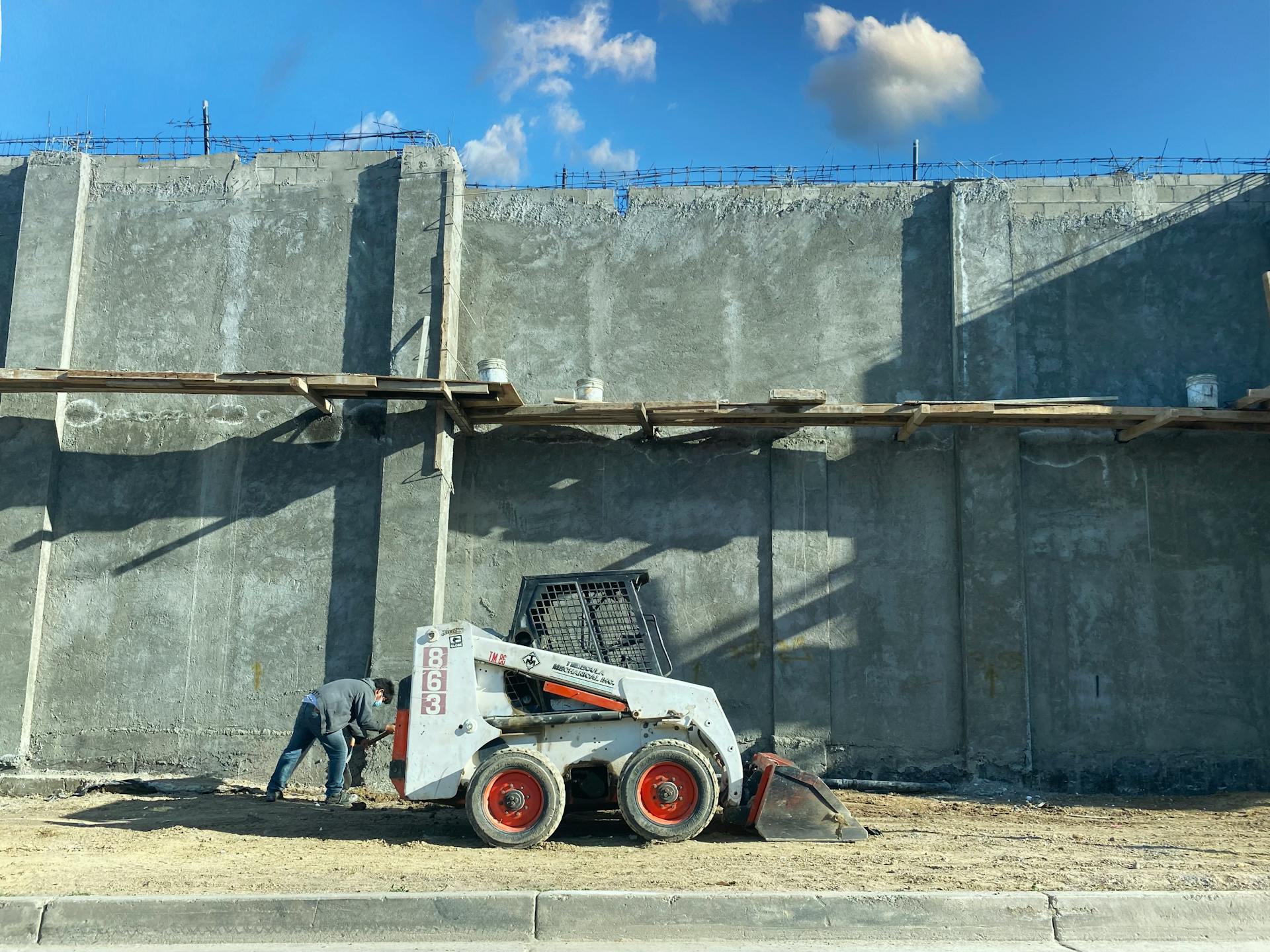 Worker operating loader at a concrete construction site. Tijuana, Mexico.