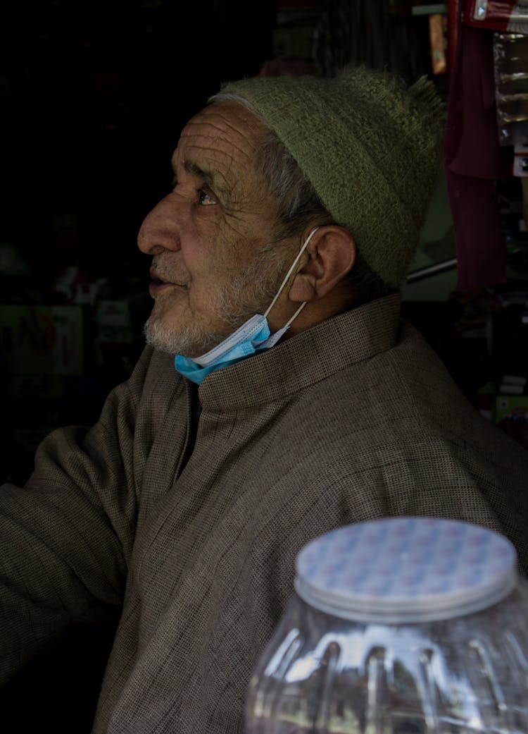 Portrait Of Elderly Man Wearing Face Mask On His Chin