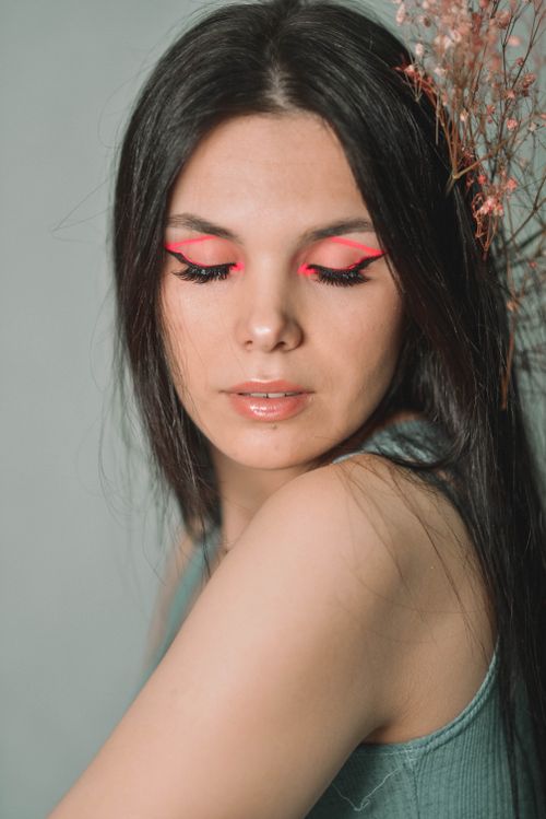 Free Close-up portrait of a young woman with striking red eye makeup and closed eyes. Stock Photo