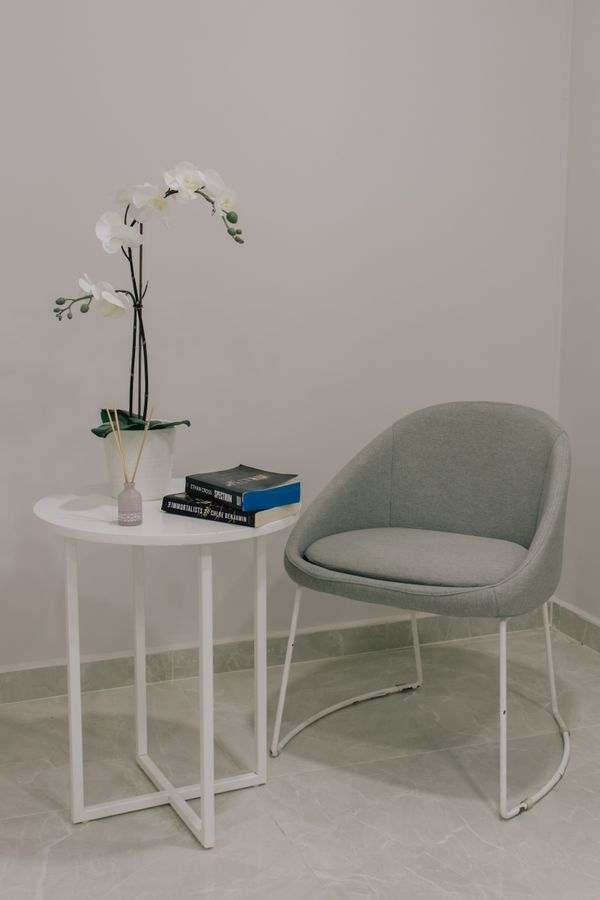 Minimalist chair beside a plaster wall, photo by Ata Ebem on Pexels