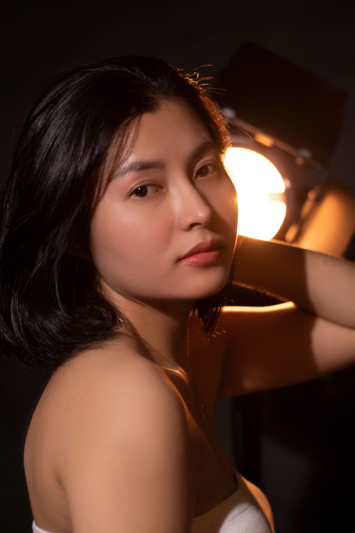 A woman with clear, glowing skin in warm, low light