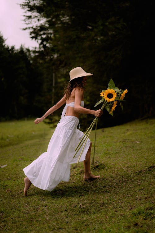 Woman Running Through a Field with Flowers 
