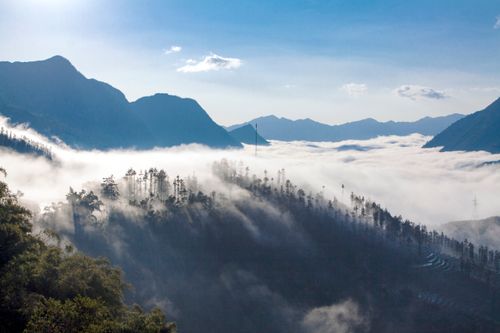 Free Peaceful mountain scene with mist and cloud cover under a clear blue sky. Stock Photo