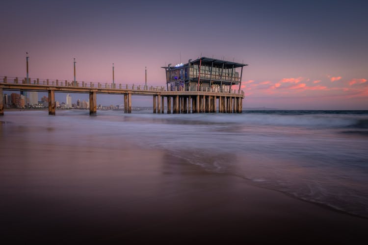 Building On Pier In Water On Sunset