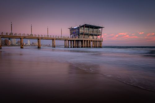 Free Capture of Durban pier at sunset, featuring a beautiful seascape with pink hues in the sky. Stock Photo