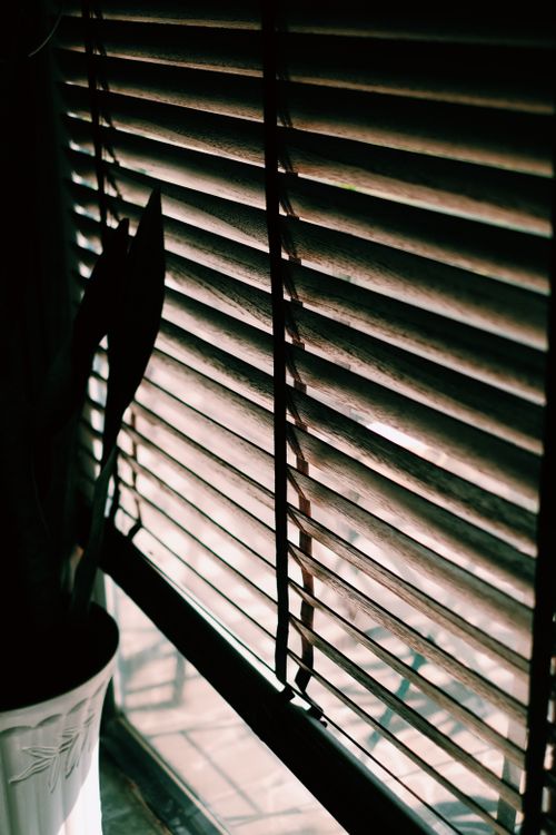 Free Close-up of sunlight filtering through wooden blinds, creating a warm, cozy indoor atmosphere. Stock Photo