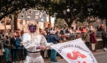 Colorful carnival parade with costumed performer in A Coruña, Spain. Energetic celebration with large crowd.