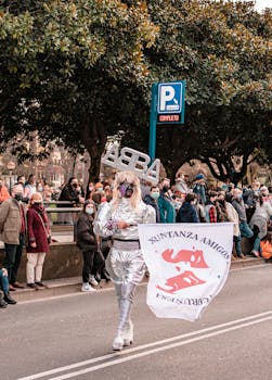 Colorful parade in A Coruña, Spain featuring costumed participants celebrating on a vibrant street.