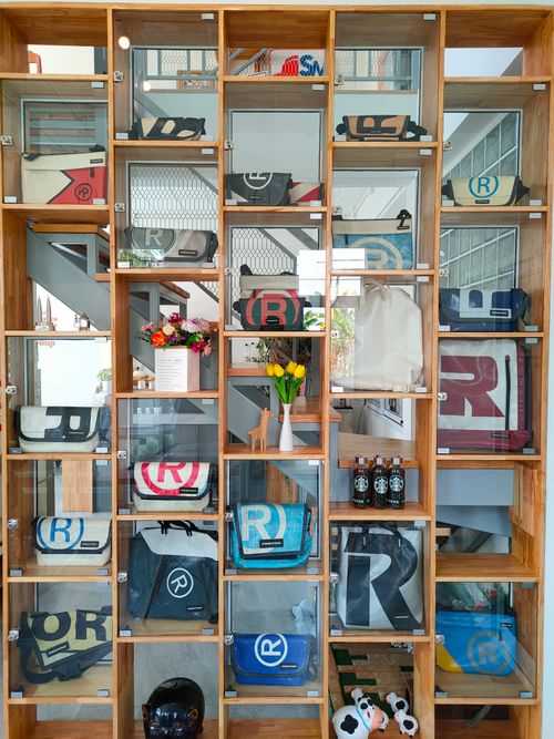 Free Stylish wooden shelf displaying colorful bags and decor items indoors. Stock Photo