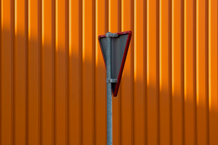 A Triangular Metal Sign On A Pole