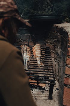 Outdoor grilling of fish on a rustic barbecue with a cozy atmosphere.