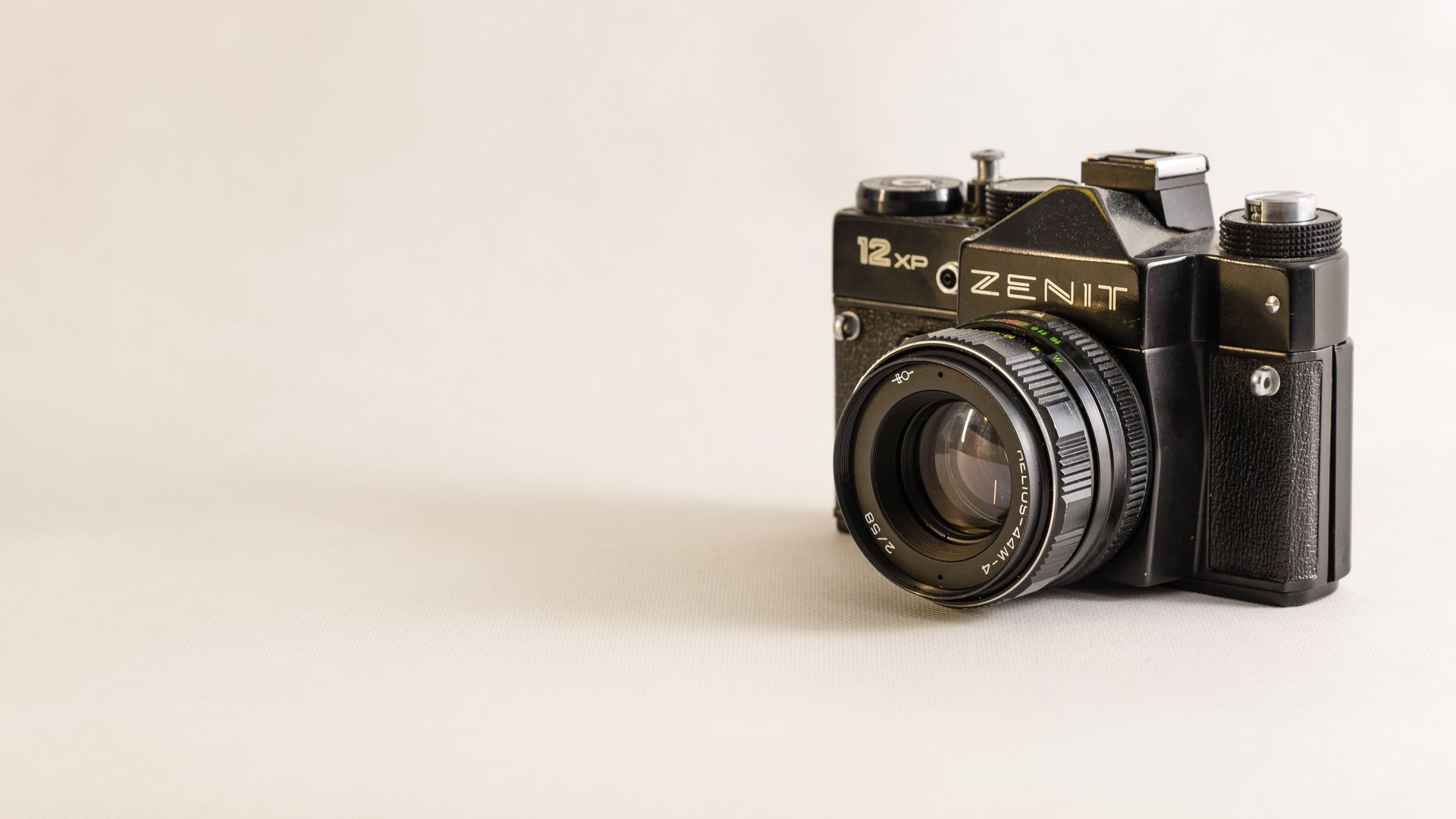 Close-up of a classic Zenit 12 XP camera showcasing vintage design on a white background.