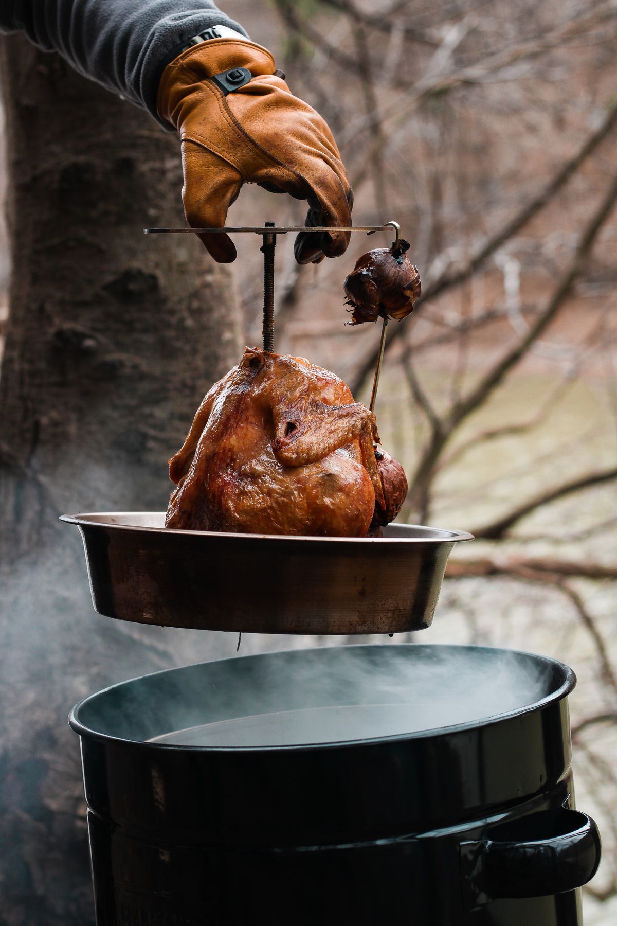 Golden smoked bird lifted from an outdoor smoker