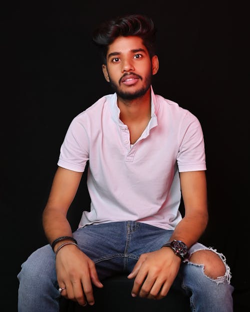 
A Bearded Man Wearing a White Polo Shirt and Denim Pants