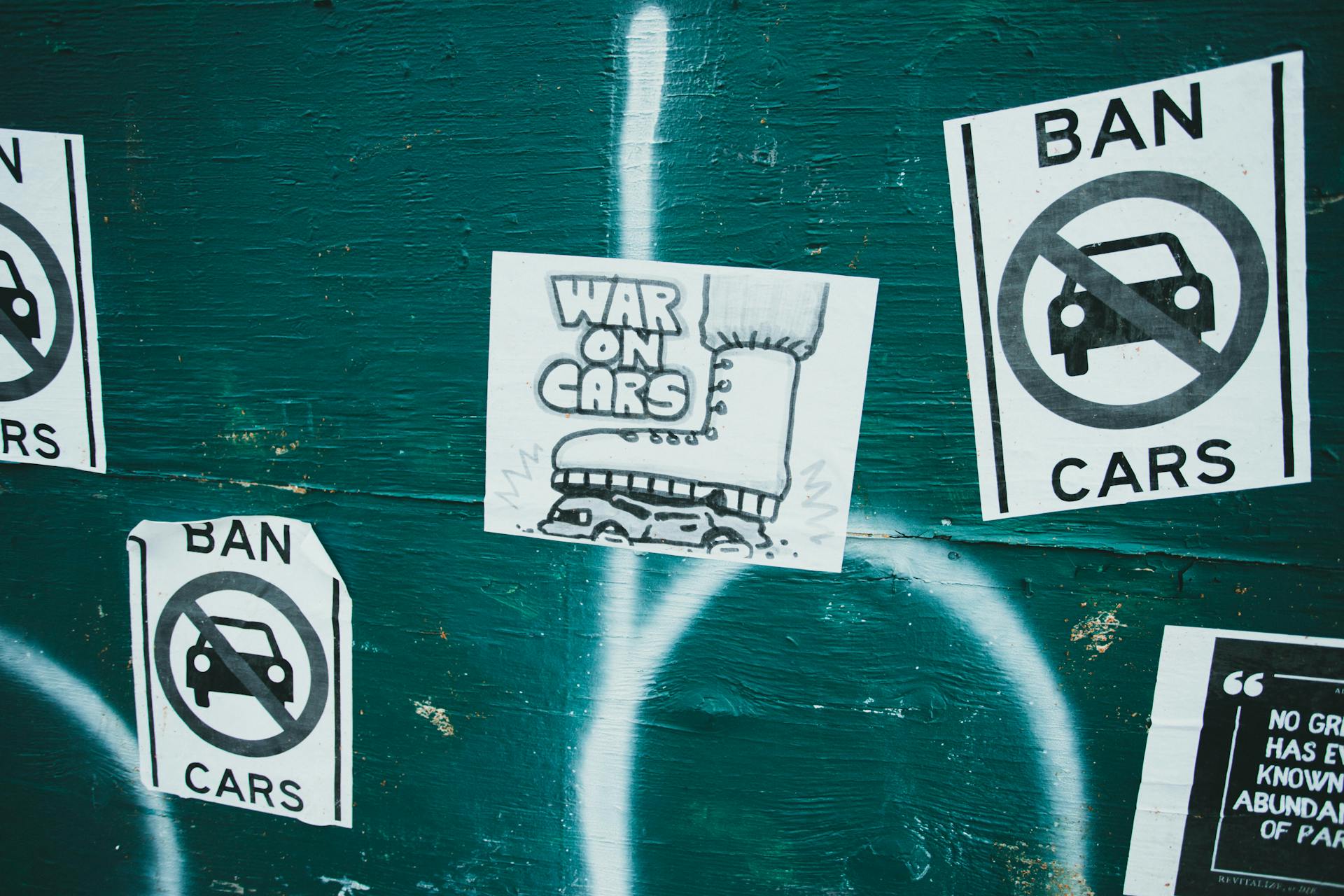 Posters of War and Ban on Cars Posted on Green Wall