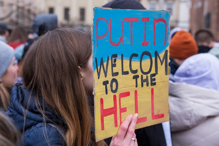 A Person Holding A Placard That Says Putin Welcome To The Hell