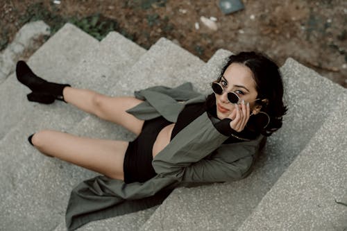 Free Woman in Black Shirt Lying on Gray Concrete Floor Stock Photo