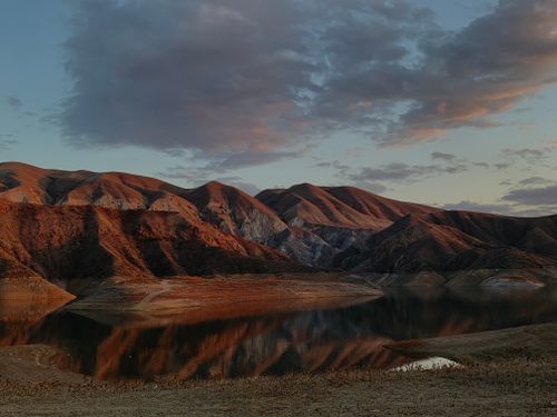 Free Calm mountain landscape with lake reflecting colorful sunset sky. Stock Photo