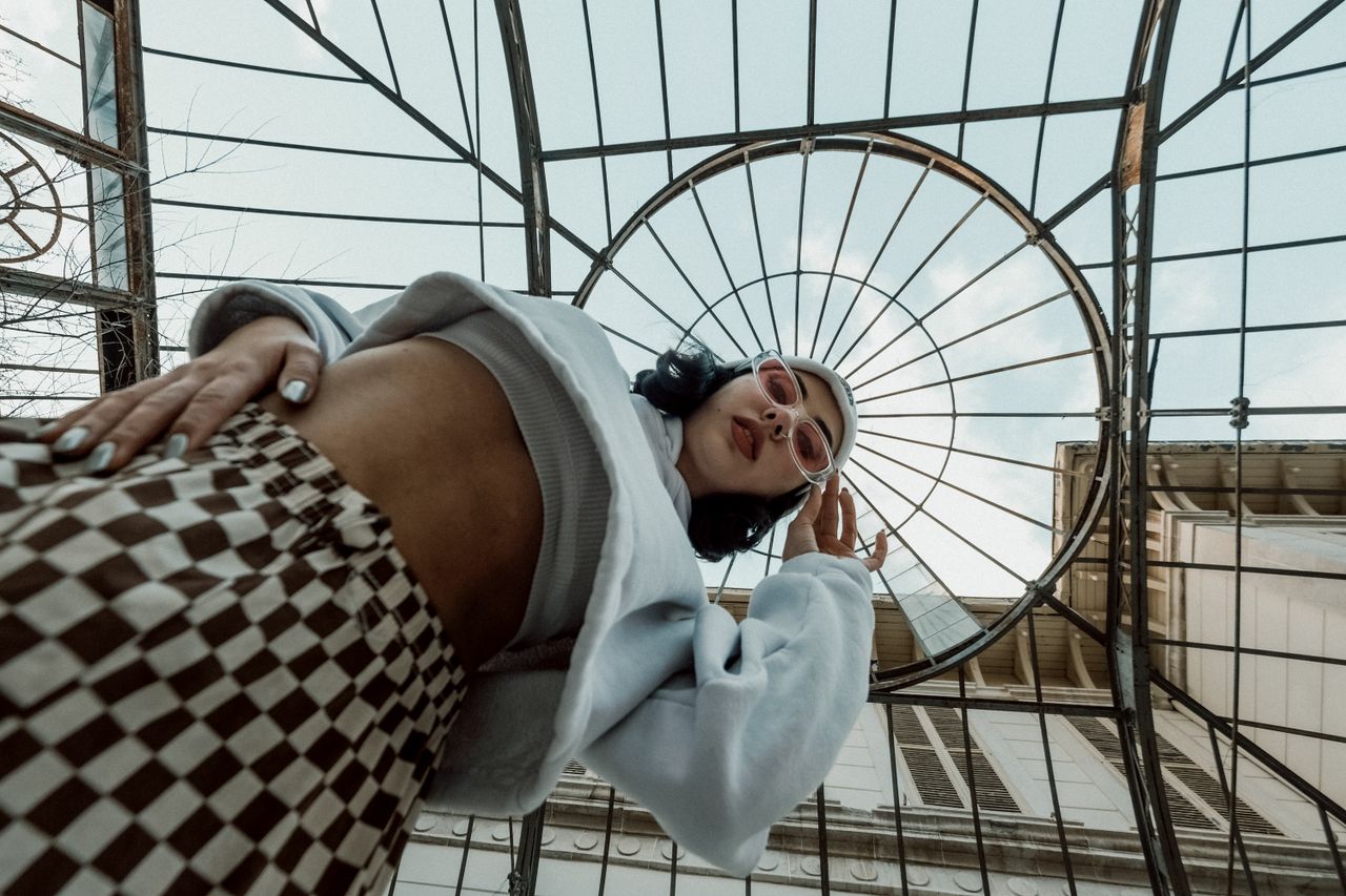 low angle shot of a fashionable woman in sunglasses with an artistic b