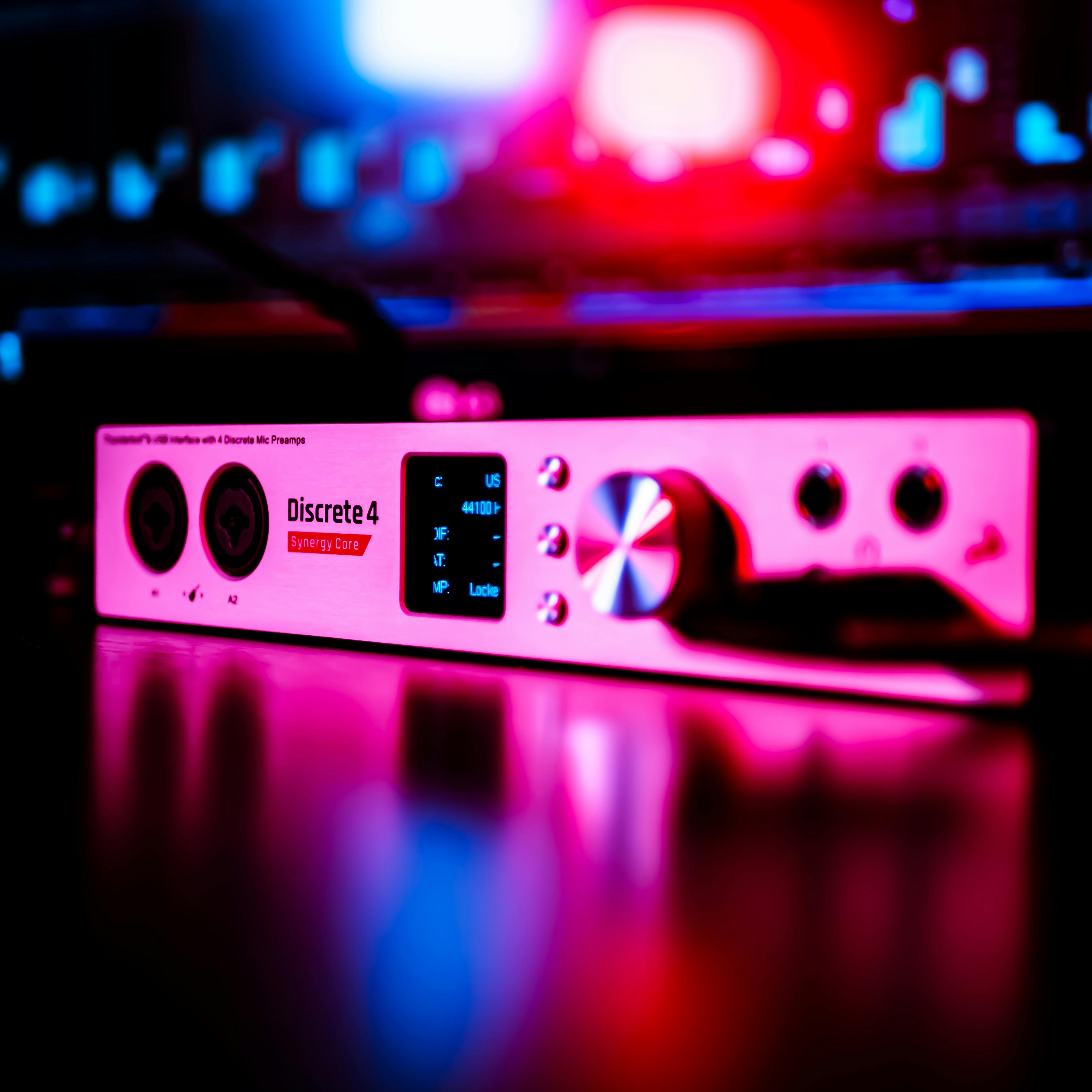 antelope discrete audio interface in a recording studio with red and blue neon light