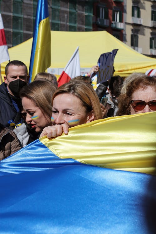 Free Women Carrying the National Flag of Ukraine during a Peaceful Protest Stock Photo