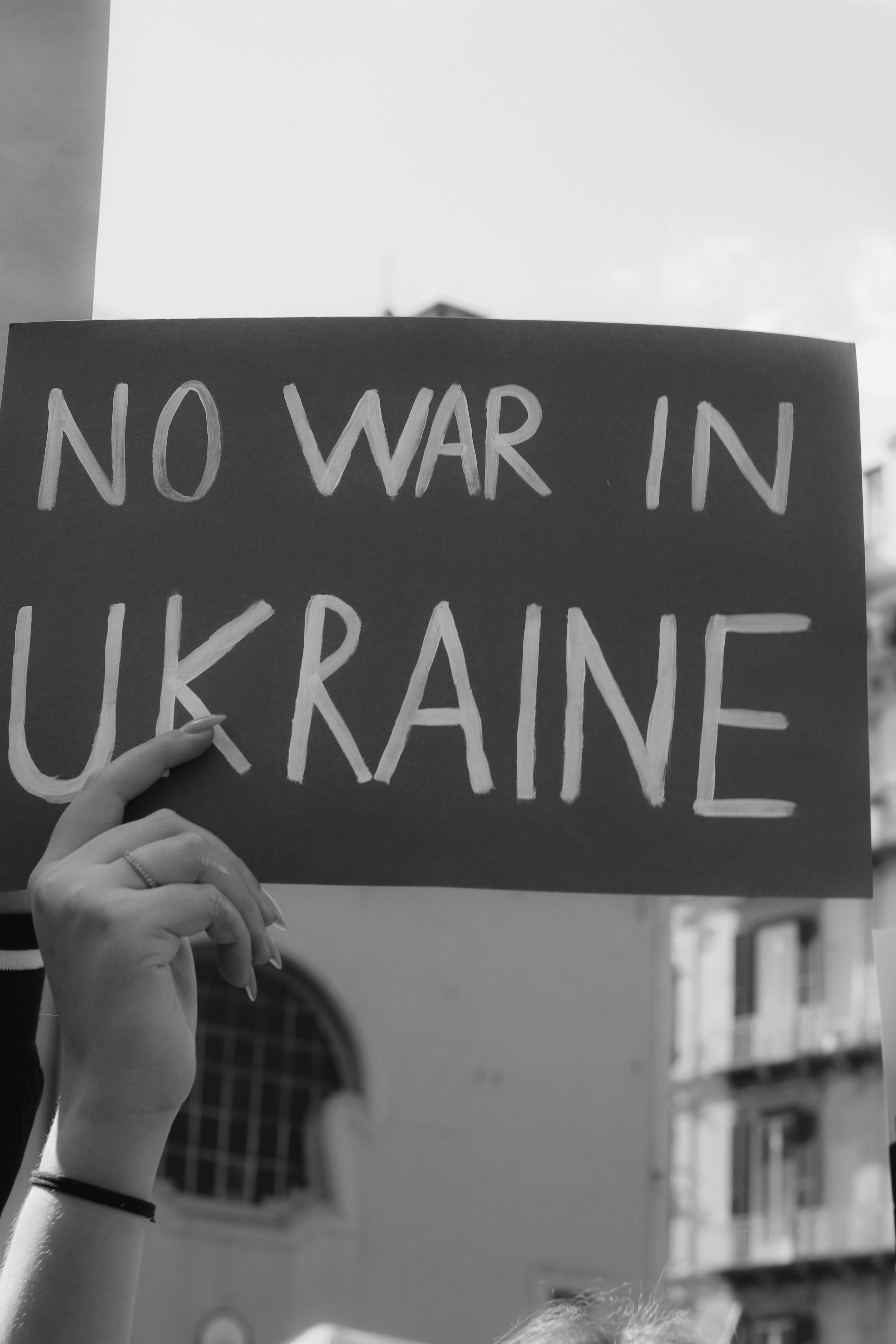 a person holding a no war in ukraine sign