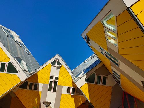Free Modern architecture of Rotterdam's Cube Houses with striking yellow designs under a clear blue sky. Stock Photo