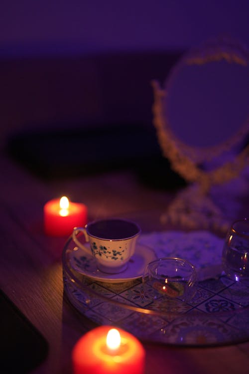 Lighted Candles Near the Ceramic Cup and Saucer 