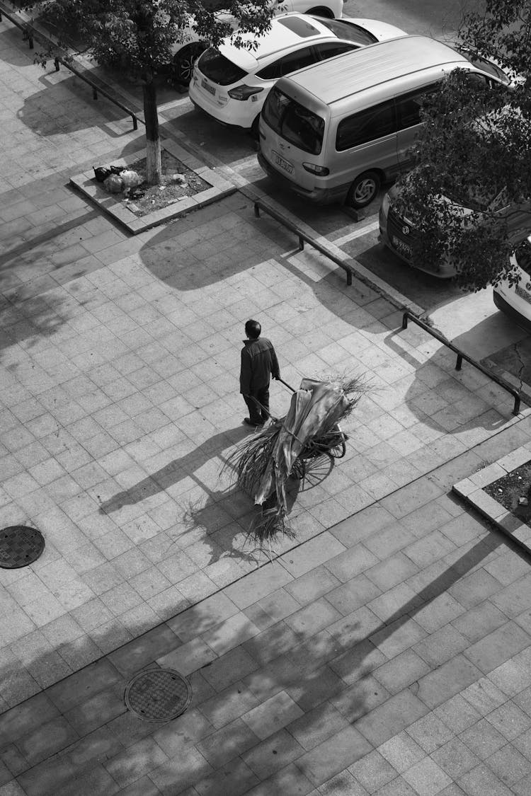 Man Standing With Cart On Pavement