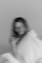Blurry Black and White Photo of a Woman Holding a Pillow