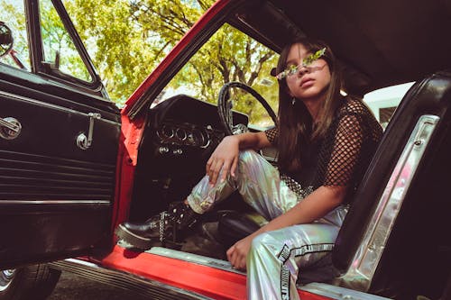 Woman in Vinyl Pants Sitting in Drivers Seat