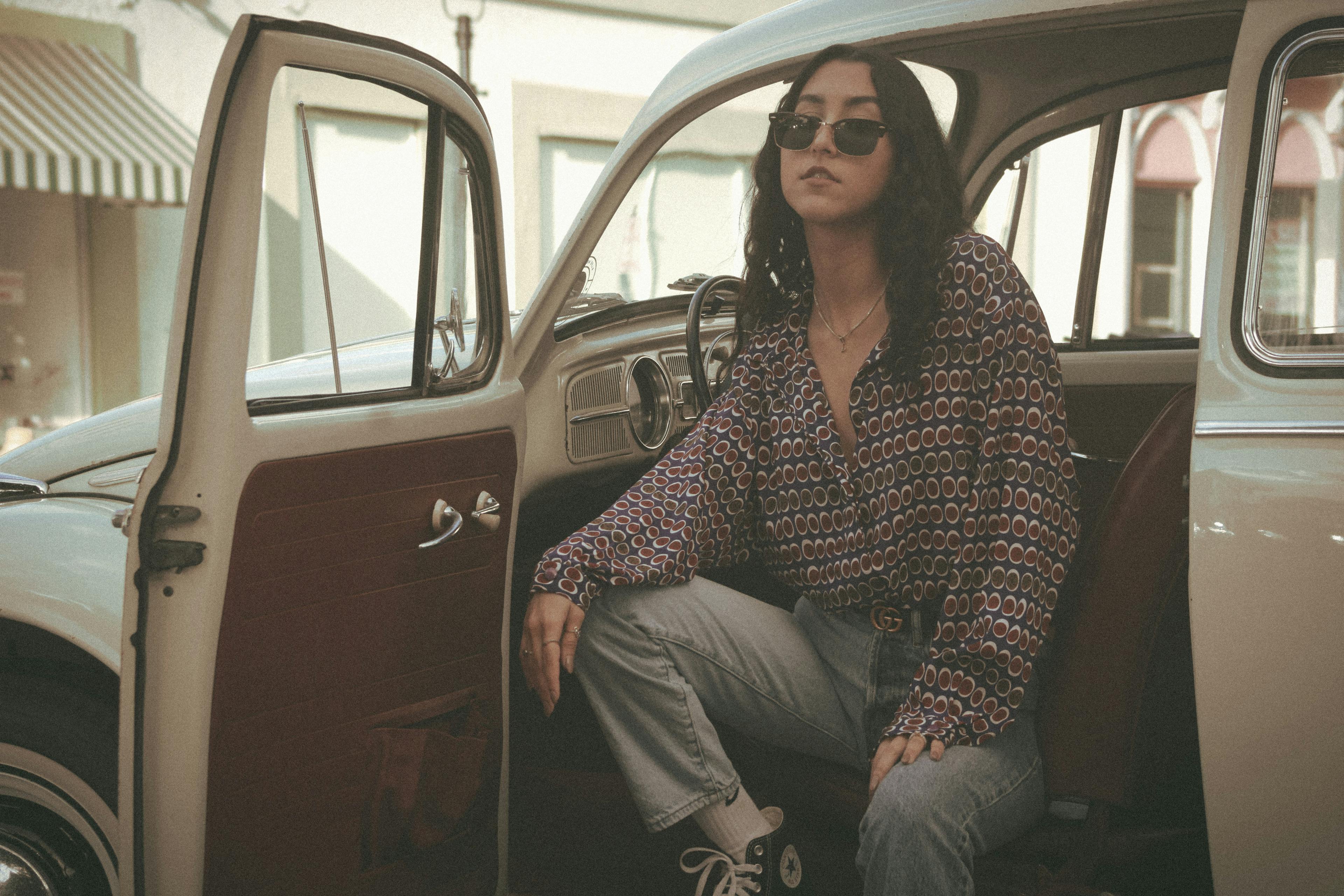 Woman Wearing Sunglasses Posing on a Classic Car